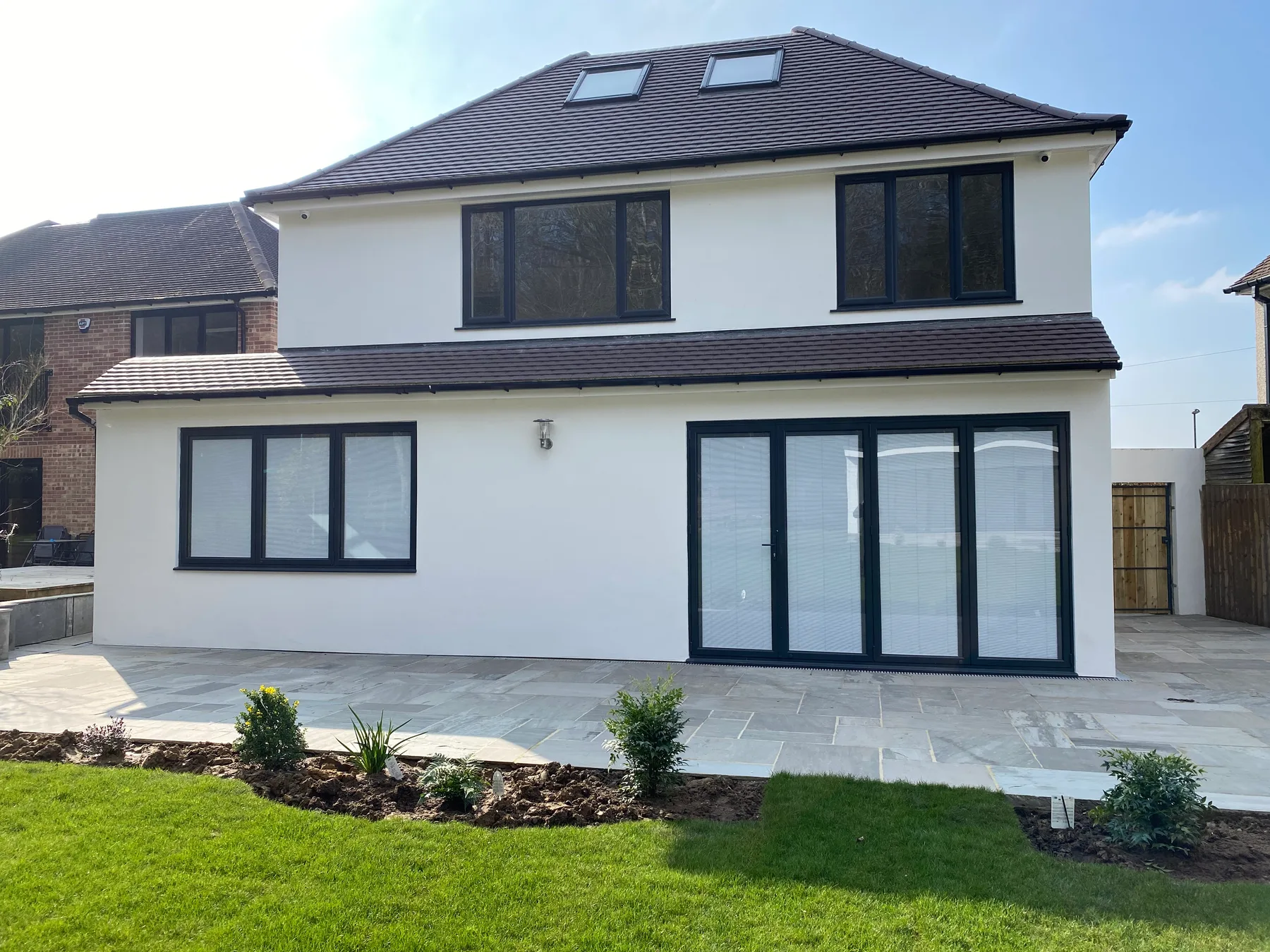 Anthracite bi-folds on a rendered garden extension