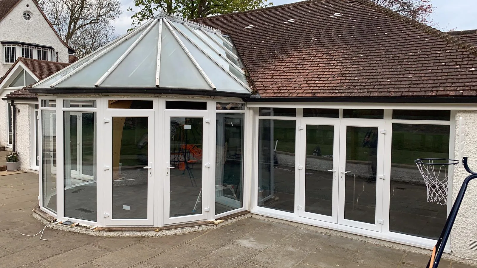 White conservatory opening onto a paved terrace
