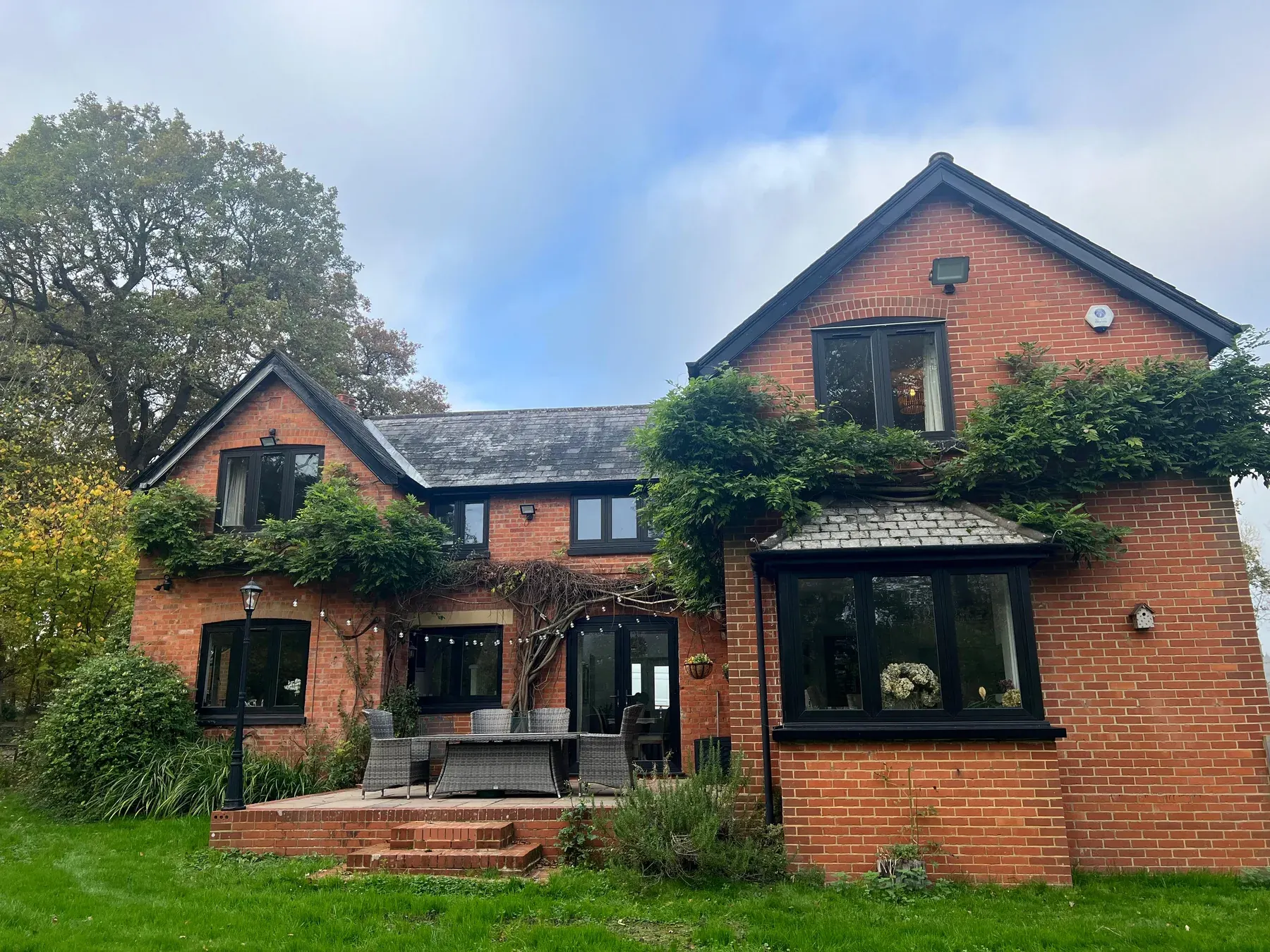 Anthracite flush windows, ivy-clad brick